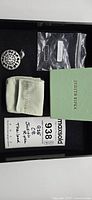 Photo showing the Judith Ripka pendant alongside original branded pouch, box, and maxsold lot tag.