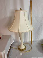 Full view of the Lenox table lamp including fabric shade and base with ruler for height reference.