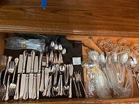Full drawer view showing assortment of flatware and napkin rings