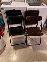 Front view of 4 vintage IKEA folding chairs, 2 black and 2 brown, showing seats and backs.