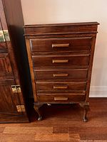 Front view of antique music cabinet next to adjacent bookcase