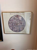 Framed Ebstorf World Map print mounted on a wall with sunlight reflection on the glass.