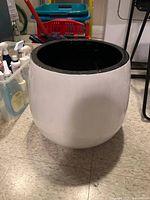 Front view of the white indoor planter showing its rounded shape and black interior