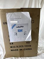 Cardboard shipping box for the 6 in 1 Kim 8 Body Slimming Machine labeled with dimensions and country of origin (Made in China).