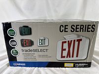 Photo of the packaging of Compass CE Series LED emergency exit signs showing product features such as LED technology, 90-minute emergency battery, and 2-year warranty, with red, green, and white EXIT sign examples.