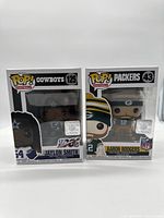 Two unopened Funko Pop football figures, Jaylon Smith Cowboys #125 and Aaron Rodgers Packers #43 side by side in their boxes.