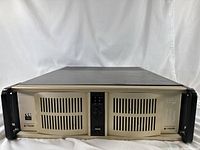 Front view of beige 2U server chassis with ventilation grilles, black side handles, and control panel in the center