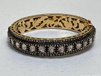 Front view of bangle showing central row of larger diamond slices set in silver overlay