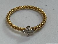 Ring on white surface showing full circumference and four-leaf clover motif