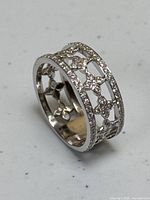 Perspective angle view of ring showing openwork lattice design and pavé-set diamonds