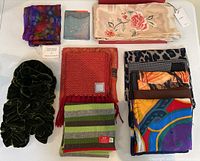 Eleven scarves arranged flat showing variety of colors and patterns