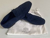 Pair of navy blue suede loafers displayed on white Sophique Milano dust bag.