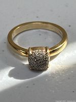 Front angle view of ring on flat surface showing cushion pavé diamond top