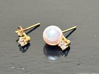 Both earrings displayed showing pearl on right earring and only diamond on left.