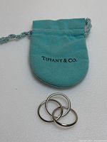 Ring placed in front of Tiffany blue velvet pouch on white background