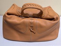 Front profile view showing stitched bow detail at center front and rolled handle