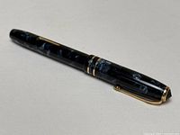 Side profile of closed pen showing overall design and resin pattern.