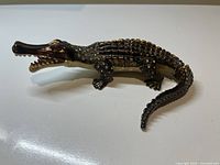 Alligator-shaped jewelled trinket box with detailed scales and open mouth, showing the profile view.