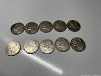 Ten Canadian 25-cent coins arranged in two rows, showing front details and average condition with some tarnish and wear.