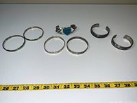 Photo showing all seven bracelets lined up with measuring tape for size reference.