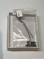 Sterling silver necklace chain with multi-coloured crystal pendant in white box with a $10 price tag in plastic sleeve.