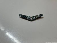 Top-down view of the vintage sterling silver brooch with opal cluster inlay on a white surface.