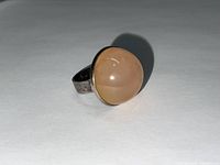 Close-up side angle of the ring showing the rose quartz cabochon and sterling silver band