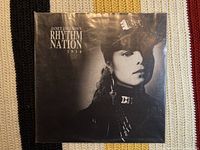 Front cover of the Janet Jackson Rhythm Nation 1814 vinyl album, showing black and white photo of Janet Jackson wearing a cap and earring.