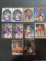 Photo showing 10 Kevin Johnson basketball trading cards from the 1990s. Cards depict both action shots and portraits in Phoenix Suns uniforms, stored in clear protective sleeves on a dark surface.