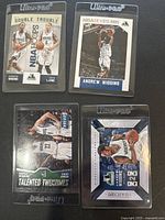 Four 2015 Panini Minnesota Timberwolves basketball cards in Ultra-Pro protective sleeves showing players including Andrew Wiggins with titles like 'Double Trouble' and 'Talented Twosomes'.