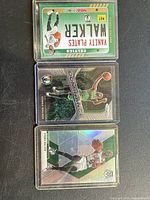 Set of three Kemba Walker basketball cards from 2020 Panini series in plastic sleeves, showing front artwork and design.