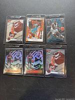 Front view of six Chris Paul basketball cards, including holographic and foil finish designs, in protective plastic cases.