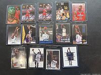 Fourteen Chris Webber collectible basketball cards arranged in rows, each card in protective sleeve, showing various poses and team uniforms