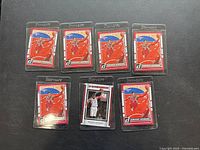 Seven Dwight Howard basketball cards arranged on a black surface. Six cards have a red-themed design featuring Howard in mid-air during a play, each in clear protective sleeves labeled 'StowSafe'. One card shows a different white and black bordered design with Howard in a white jersey.