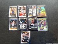 Nine Nikoca Jokic basketball cards on a black surface, each in protective clear sleeve, showing a variety of designs and holographic elements.