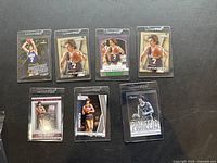 Front view of five Pete Maravich basketball cards in protective sleeves lying flat