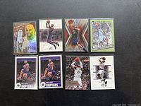 Photo showing 8 basketball cards featuring Vince Carter in various artistic and brand styles arranged on a dark surface.