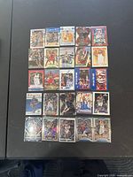 View of 25 basketball trading cards arranged in rows on a dark surface showing fronts with player images and special edition designs