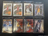 Photo of all eight Donovan Mitchell basketball trading cards arranged in two rows, showing Panini branding and Ultra Pro protective sleeves