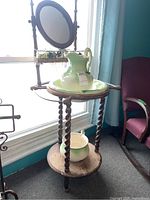 Front view of the washstand set showing pitcher and basin on top shelf and chamber pot below