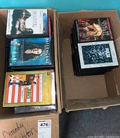 Photo showing two open boxes filled with DVDs including titles Juno, Carte Blanche, Passengers, Drag Me to Hell, and Pulse.