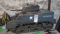 Side view of the M5 Stuart tank model showing treads, side armor, star insignia, and ID number USA 3047999