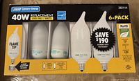 Front view of 6-pack containing flame tip 40W replacement CFL light bulbs with energy saving features and base adapters.