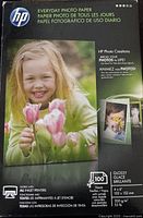 Front of the HP Everyday Photo Paper package with image of a young child holding tulips, showing branding and photo examples.