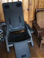 Photo of a black Backsaver locking recliner chair frame missing its seat cushion but includes armrests and Velcro spots for cushion attachment.