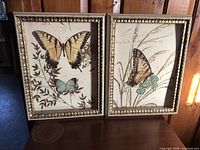 Photo showing matching antique style butterfly prints framed in gold-colored frames with botanical and script background details.