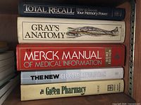 Five books stacked on a shelf, titles visible on the spines.