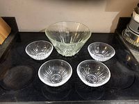 Photo showing one large Princess House lead crystal bowl and four matching smaller lead crystal salad bowls arranged on a black surface.