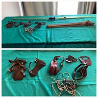 Photo of all archery items arranged on a green fabric surface: the fiberglass bow, wooden arrows, leather wrist and finger protectors, and extra bowstring.