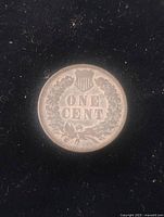 Close-up of the reverse side of the 1902 Indian Head one cent coin showing detailed wreath and shield design with "ONE CENT" denomination.